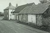 Falmer village towards the main road from the pond side of the village. On the right is a single storey barn in flint and brick with Slark's garage on the corner