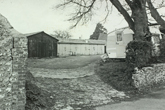 Falmer village showing a rather derelict site with some sheds a wooden barn and a caravan