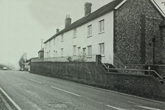 Looking North Falmer village showing Slark's garage in the distance and cottages set up steps from the A27
