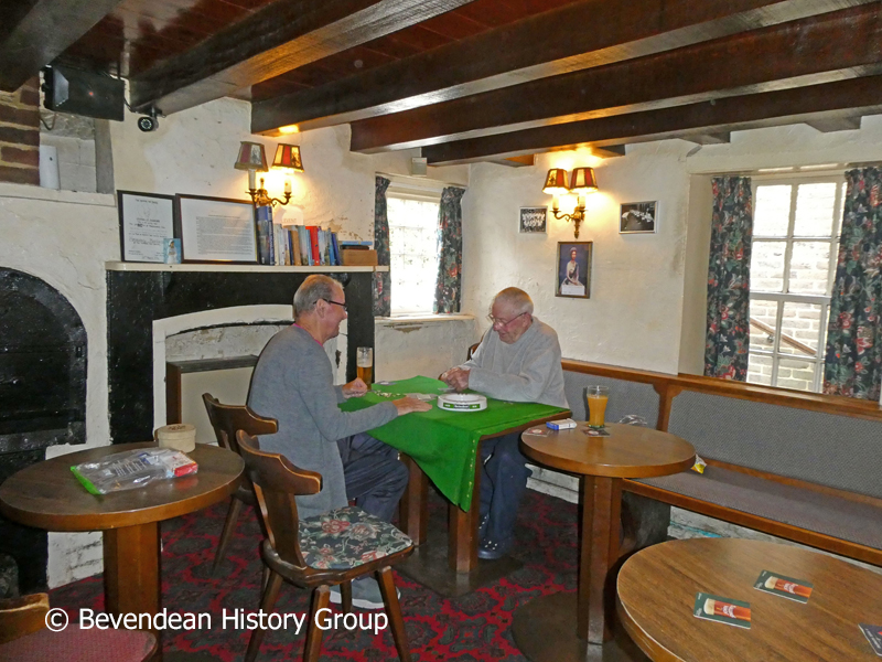 Two gentlemen playing cards in the original cottage