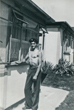 Brian by the front of their prefab 9/8/1953